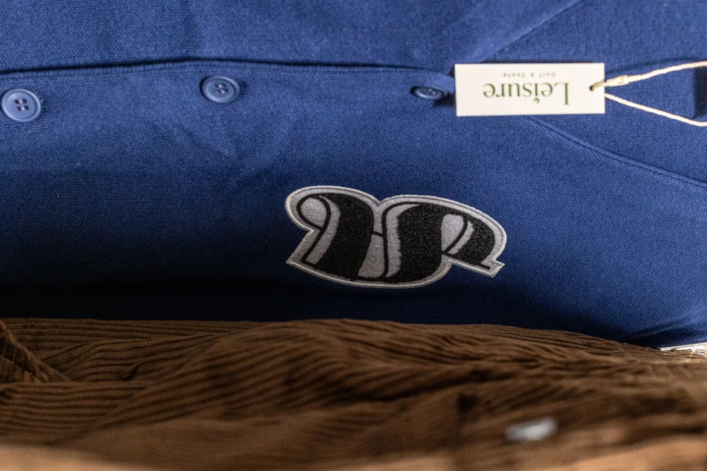 Navy cardigan with chenille S patch and Leisure hangtag